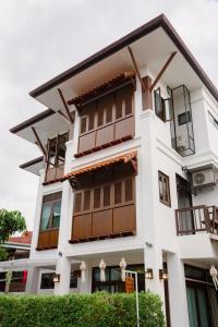 - un bâtiment blanc avec balcon dans l'établissement Huen Hug Chiang Mai, à Chiang Mai