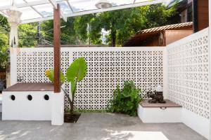 a white fence with a plant on a patio at Huen Hug Chiang Mai in Chiang Mai