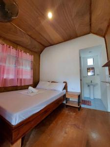 a bedroom with a bed and a small table at Jake and Zyra Place in San Vicente +13 photos