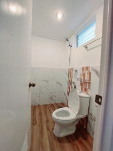 a bathroom with a white toilet and a window at Jake and Zyra Place in San Vicente