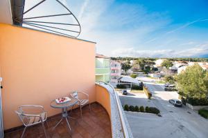a balcony with a table and chairs and a street at Apartments PREMANTURA DOM in Premantura