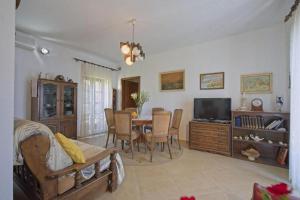 a living room with a table and a tv at Apartments Lucija in Postira