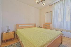 a bedroom with a bed and a dresser and a window at Apartments Lucija in Postira