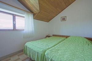 a bedroom with a green bed and a window at Apartments Lucija in Postira