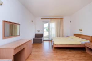 a hotel room with two beds and a mirror at Apartments Josip S in Lopar