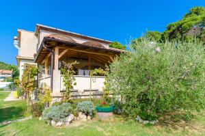 a house with a bunch of plants in the yard at Apartments Josip S in Lopar