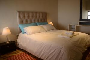 1 dormitorio con 1 cama blanca grande y toallas. en CASA LUYA URCO, en Chachapoyas