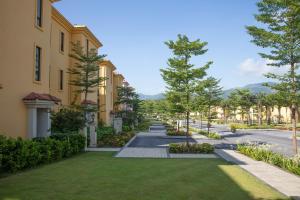 Une rangée de maisons dans une rue arborée dans l'établissement Wyndham Sky Lake Resort and Villas, à Hanoï