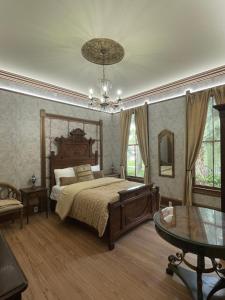 a bedroom with a bed and a table and a chandelier at 1001 Nights Historic Bed and Breakfast Adults Only in St. Augustine