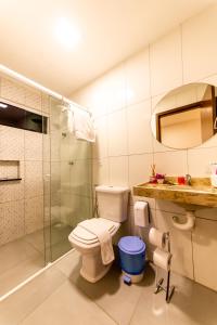 uma casa de banho com um WC e uma cabina de duche em vidro. em Barra De Maragogi Pousada em Maragogi