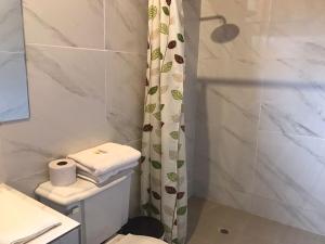 a bathroom with a toilet and a shower at Hostería los Cedros de Mindo in Mindo
