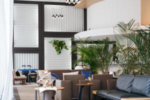 a lobby with couches and plants in a room at Hotel JAL City Haneda Tokyo in Tokyo