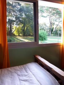 Dormitorio con ventana con cama y vistas en EL DELFiNSERRANO en Sierra de los Padres