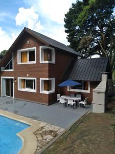 una casa con mesa, sillas y piscina en EL DELFiNSERRANO en Sierra de los Padres