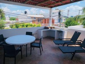 a patio with a table and chairs on a balcony at Casa Boca in Boca del Río