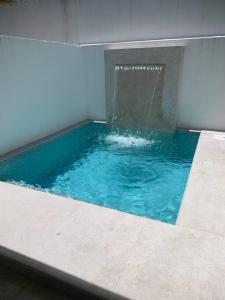 a pool of blue water with a fountain at Casa Boca in Boca del Río
