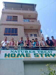 a group of people sitting on a balcony of a building at Natures Treat Homestay in Tānsen