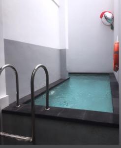 uma piscina de água numa casa de banho com duas torneiras em Ara Inn Bed And Breakfast by ecommerceloka em Kuta