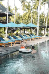two people sitting in the swimming pool at a resort at The Kirana Tembok in Tejakula