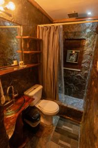 a bathroom with a toilet and a shower at Hotel Juayua in Juayúa