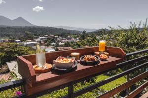 een tafel met twee kommen eten en een glas sinaasappelsap bij Hotel Juayua in Juayúa