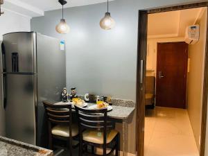 a kitchen with a refrigerator and a table with chairs at Blue Sunset Prime com vista para mar in João Pessoa +38 photos