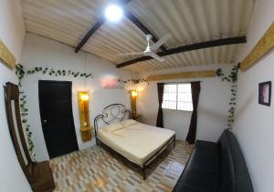 Schlafzimmer mit einem Bett und einem Deckenventilator in der Unterkunft Akainoie in Minca