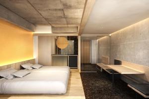 um quarto com uma cama grande e uma secretária em Kyoto ITOYA Hotel Mon em Quioto