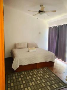 1 dormitorio con 1 cama y ventilador de techo en CASA MANDINGA en Conchal
