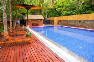 a swimming pool with chairs and an umbrella on a wooden deck at Bagan View Hotel in Bagan