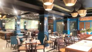a dining room with tables and chairs and lights at Luminor Hotel Palembang by WH Free Massage 10 Minutes in Palembang