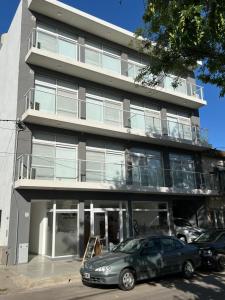 a building with cars parked in front of it at Apart hotel Magda in Venado Tuerto