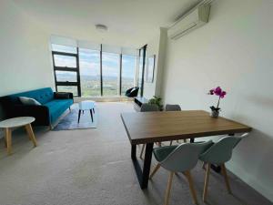 uma sala de estar com uma mesa e um sofá azul em Panoramic City View 3bed2bath condo Wi-Fi Parking em Sydney
