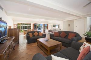 a living room with two couches and a tv at 15 Mossman Court Noosa Sound in Noosa Heads