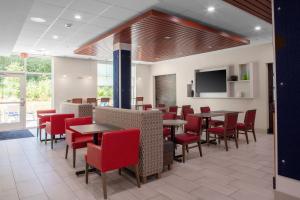 una sala da pranzo con tavoli e sedie rosse di Holiday Inn Express - Wells-Ogunquit-Kennebunk, an IHG Hotel a Wells