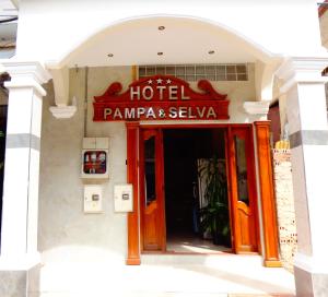a hotel entrance with a sign on a building at Pampa & Selva in Rurrenabaque