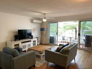 a living room with two couches and a tv at Bayview Bay Apartments and Marina in Gold Coast