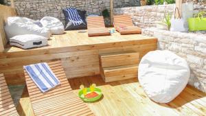 a wooden deck with chairs and a bench and a table at Eco Sunshine Apartments Lumbarda in Lumbarda
