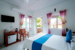 a bedroom with a bed and a desk and a tv at Thai Tan Tien Hotel in Phu Quoc