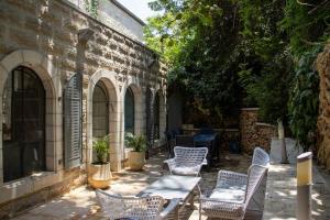 a patio with chairs and a table and a building at Cozy Heritage Home Jerusalem in Jerusalem
