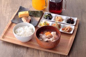 a wooden tray with a bowl of rice and a plate of food at remm Akihabara in Tokyo