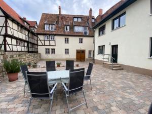 eine Terrasse mit einem Tisch und Stühlen im Innenhof in der Unterkunft Apartment am Pulverturm in Quedlinburg