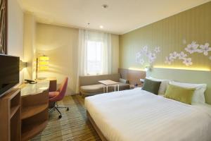 武蔵野市にある吉祥寺エクセルホテル東急の大きなベッドとデスクが備わるホテルルームです。