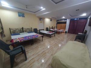 Cette chambre comprend deux lits, un canapé et des chaises. dans l'établissement Hotel Grand Murud janjira, à Murud