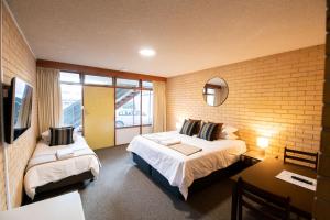 ein Hotelzimmer mit 2 Betten und einem TV in der Unterkunft Bentley's Hotel in Clare