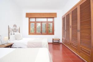 1 dormitorio con 2 camas y ventana en Del Parque Flats Villa Sauce, en Chilches