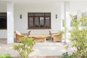 patio z kanapą i wiklinowymi krzesłami w obiekcie Del Parque Flats Villa Sauce w mieście Chilches
