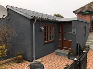 ein graues Haus mit einer Tür und einer Terrasse in der Unterkunft Ikast Bed & Kitchen in Ikast