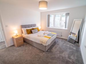a bedroom with a large bed and a mirror at Pass the Keys Centrally located beautiful 3 bed new build home in Nottingham