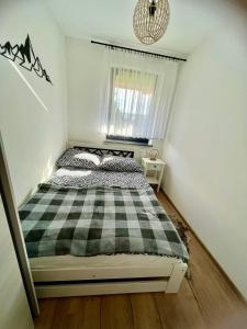 1 dormitorio con cama a cuadros en blanco y negro en Apartament w Białce Tatrzańskiej en Białka Tatrzanska